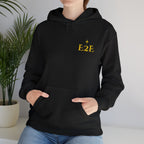 Person wearing a black hoodie with an ‘E2E’ logo on the chest, standing against a neutral background.